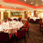 The buchanan suite set for a wedding breakfast with red lighting at mercure glasgow city hotel