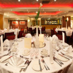 The buchanan suite set for a wedding breakfast with red lighting at mercure glasgow city hotel