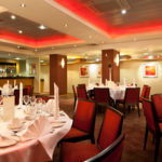 The buchanan suite set for a wedding breakfast with red lighting at mercure glasgow city hotel