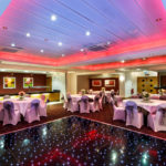 The buchanan suite set for a wedding breakfast with the dance floor lit up at mercure glasgow city hotel