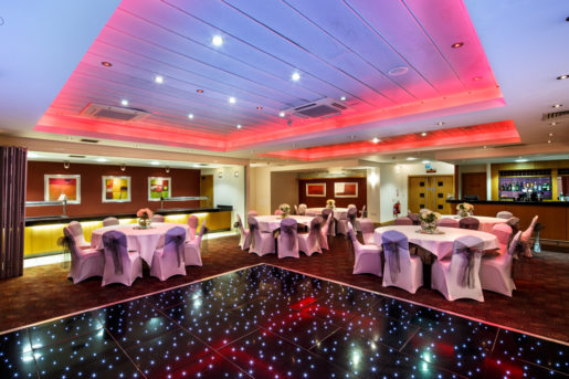 The buchanan suite set for a wedding breakfast with the dance floor lit up at mercure glasgow city hotel