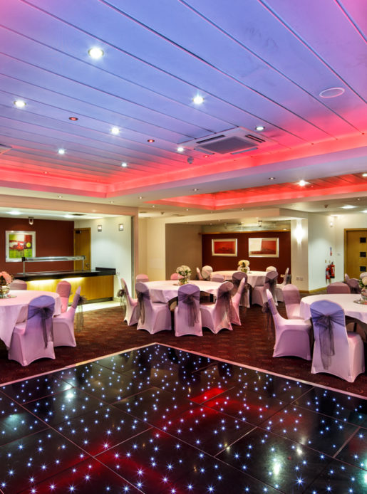 The buchanan suite set for a wedding breakfast with the dance floor lit up at mercure glasgow city hotel