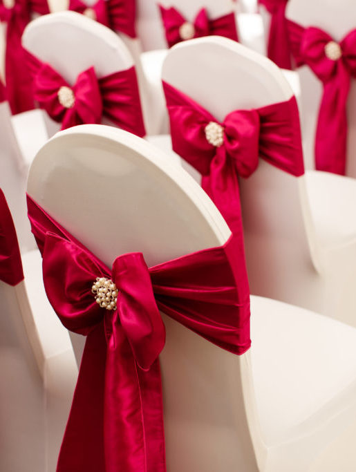 Close up of a dressed chair with a red ribbon prepared for a wedding at mercure hotels