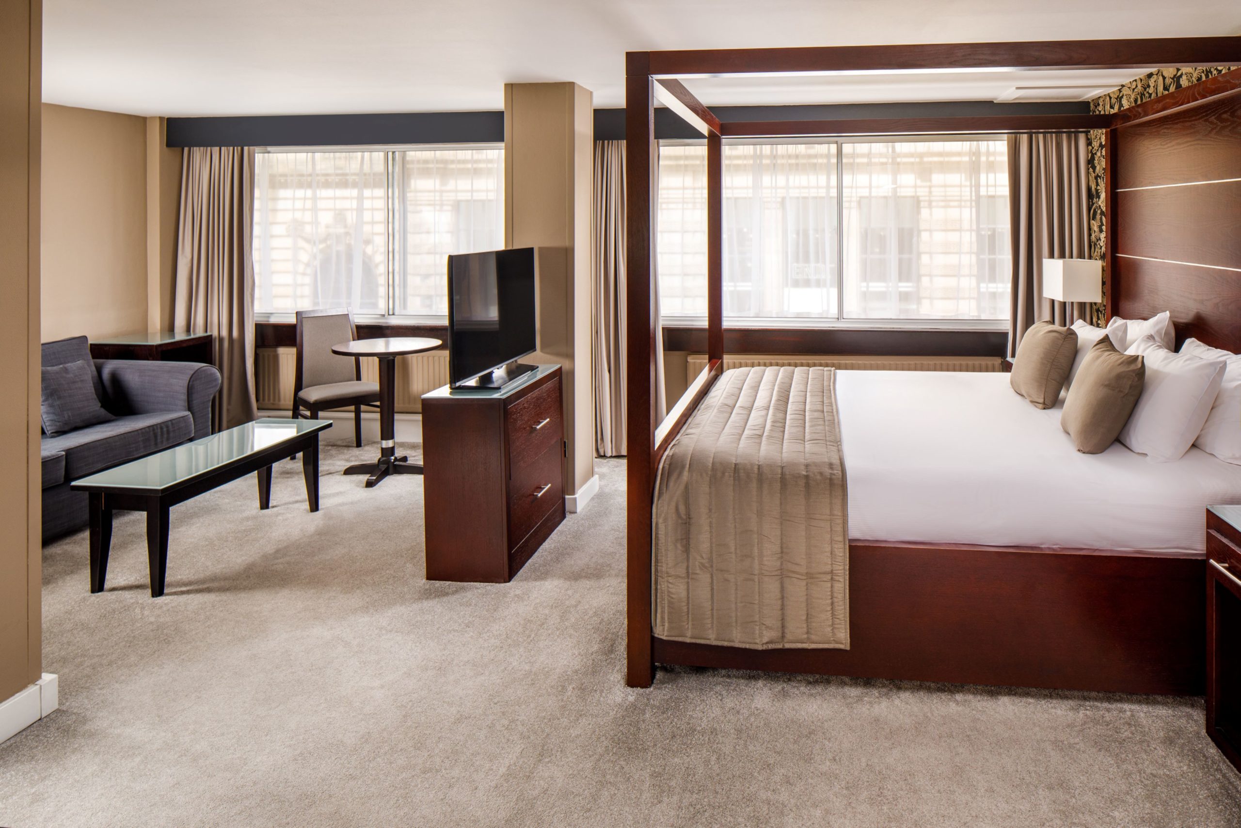 Four poster bed with nighttime picture window view in a superior room at mercure manchester piccadilly hotel