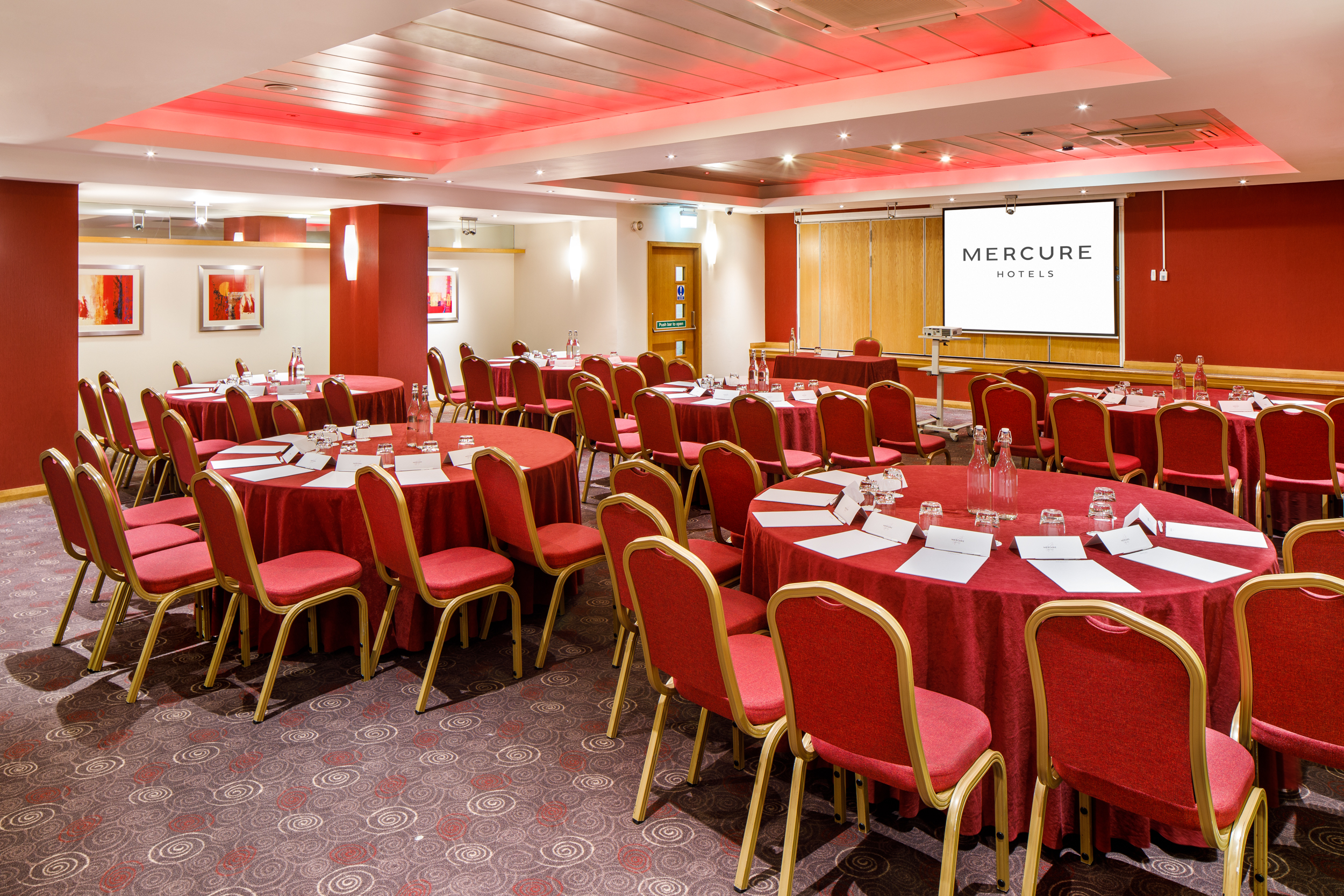 Angled view of The Lakeside Suite at mercure gloucester bowden hall hotel ready for a conference and presentation on the large video screen